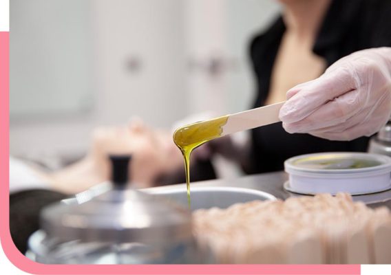 person dipping stick into hot wax