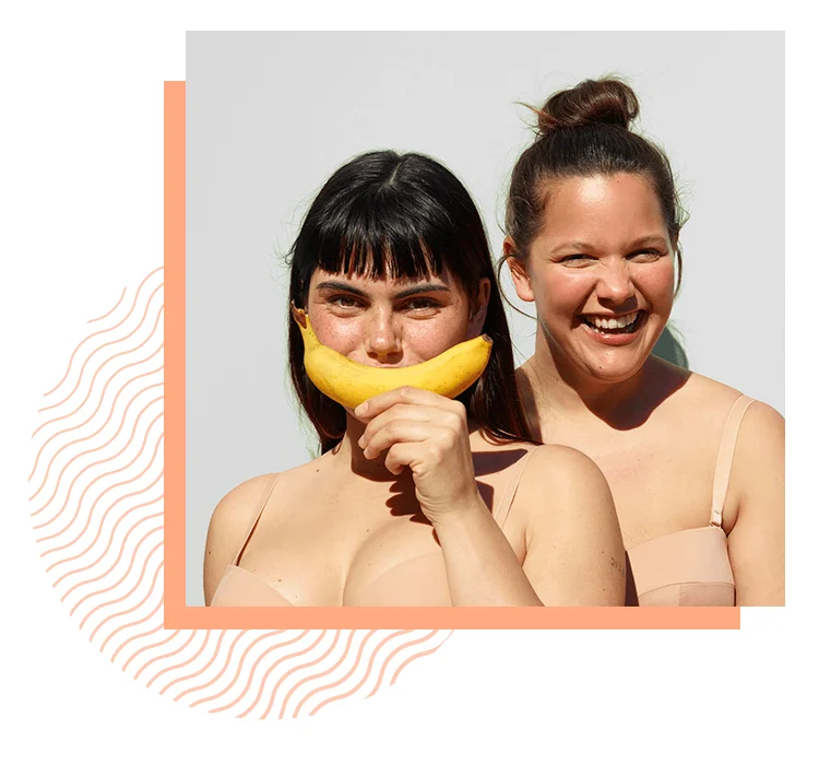 Two women smiling with a banana